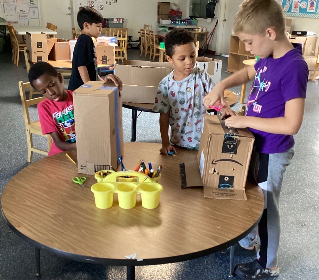 Children building and creating together at a classroom table.